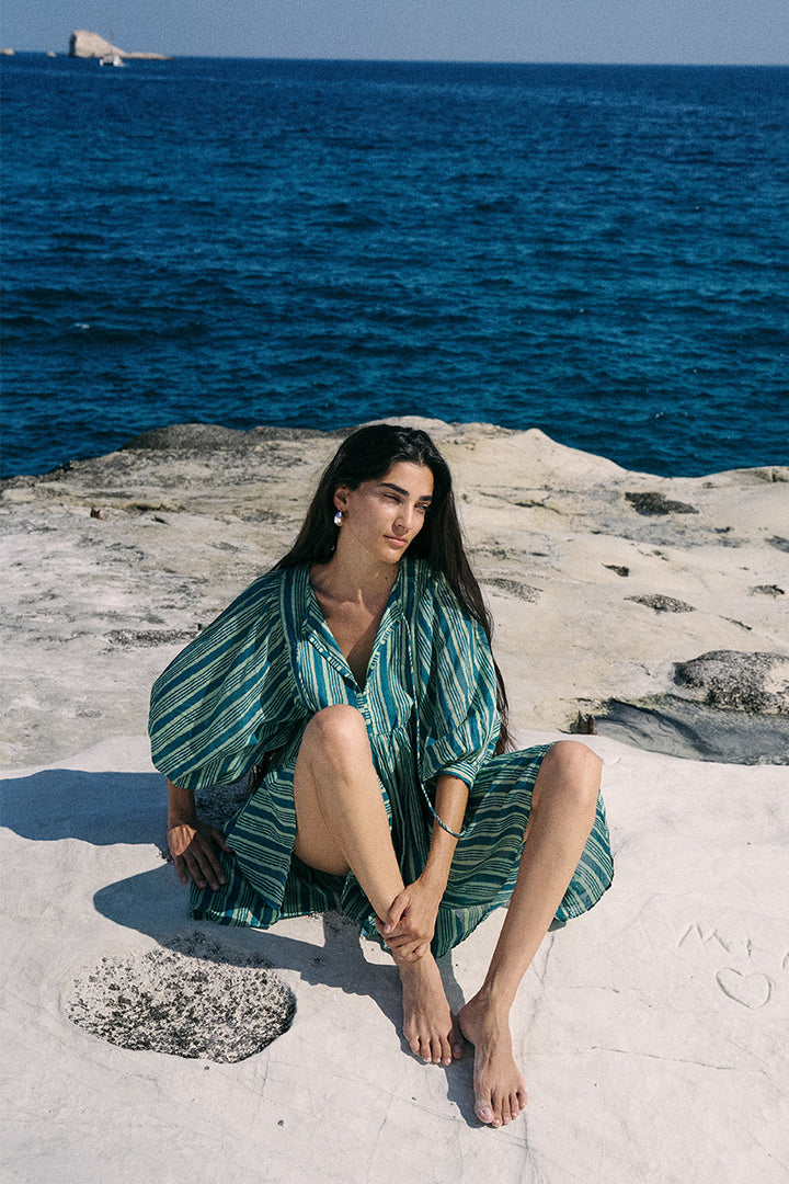 Woman sitting on a white cliff with ocean in the background