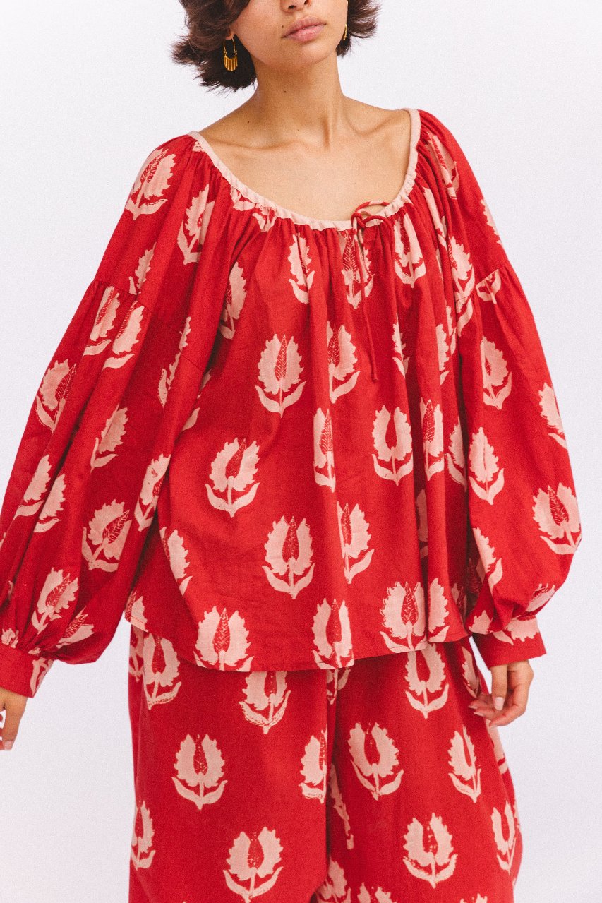 Ria Blouse Ruby Red — studio side angle view, model wearing ruby red hand block print cotton blouse and pants set, botanical leaf motif detail, relaxed contemporary fit, artisan Jaipur India | Daughters of India