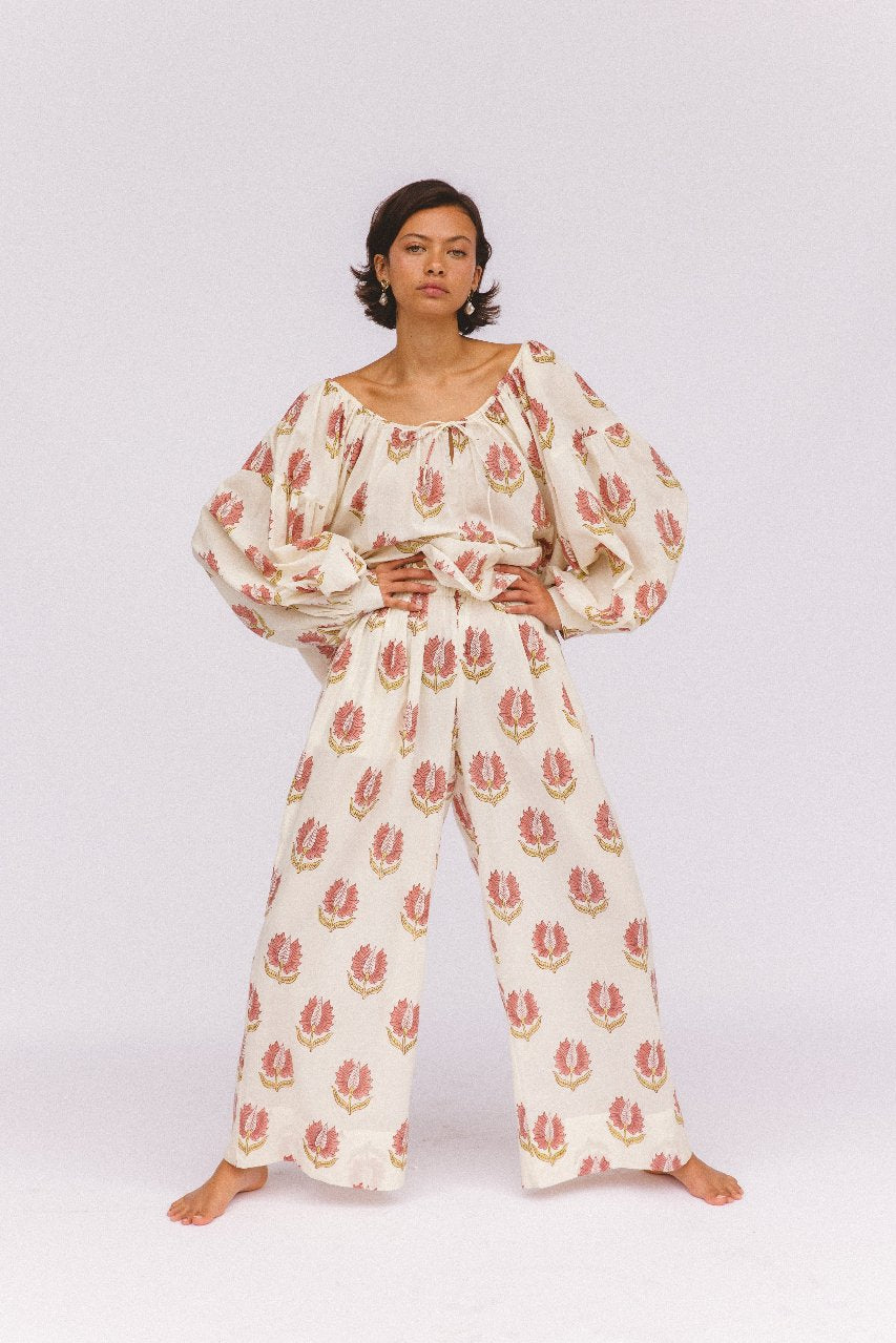 Ria Blouse Strawberry Cream — outdoor lifestyle portrait, model in natural setting, strawberry cream block print cotton blouse, Jaipur artisan made | Daughters of India