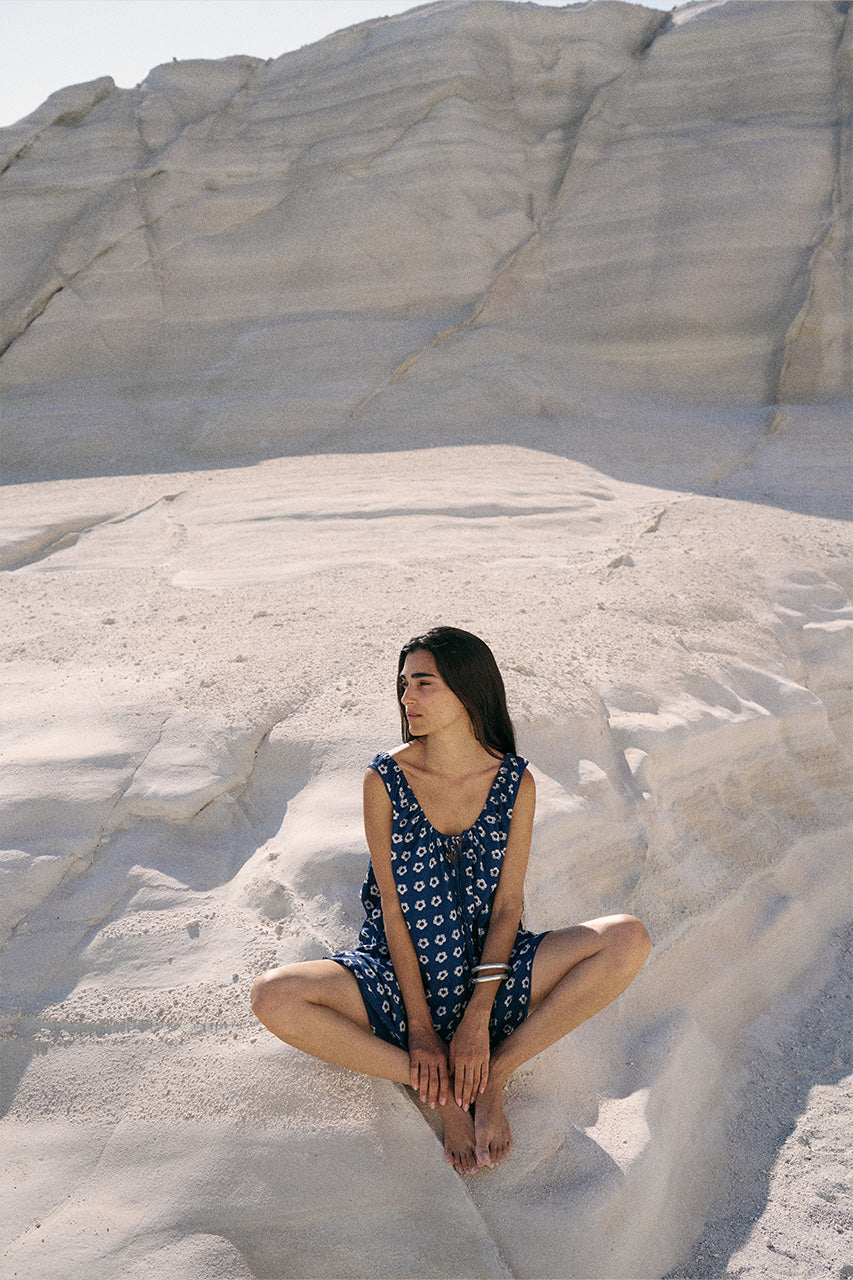 Sundress Mini Indigo — seated on white sand rocks, hand block print indigo mini dress lifestyle | Daughters of India